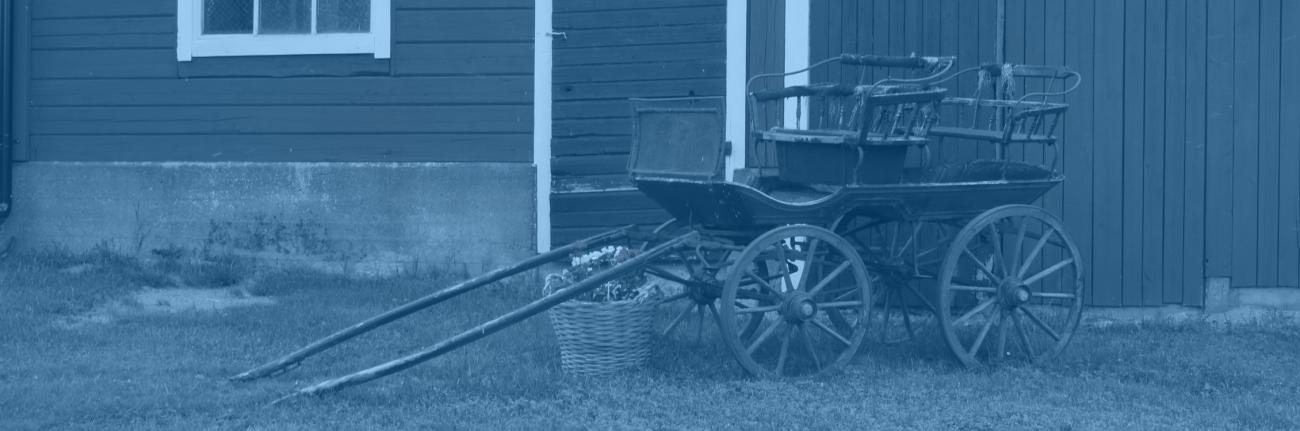 Hus med en äldre vagn framför.